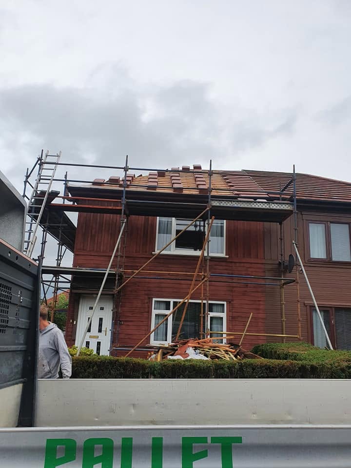 Residential tiled roof replacement in progress with scaffolding